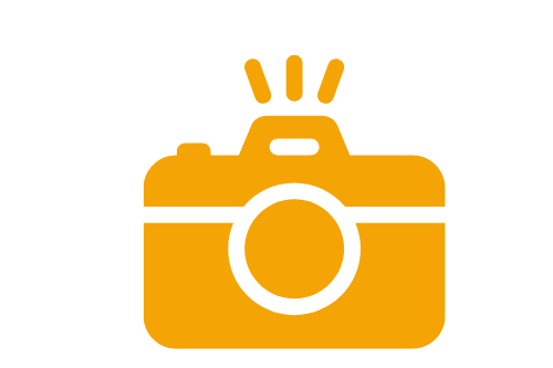 Eine orangefarbene Kamera mit einem Blitzsymbol oben.