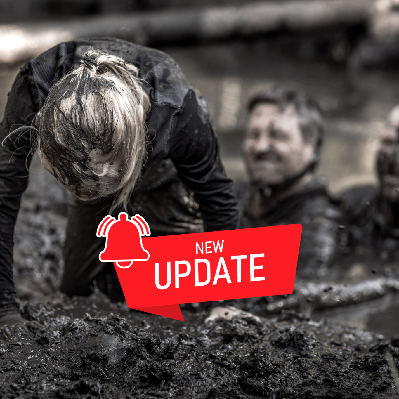 Person im Matsch, lächelt; zwei weitere Personen im Hintergrund, daneben ein Update-Logo.